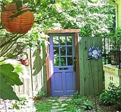 a blue door sits in the middle of a garden