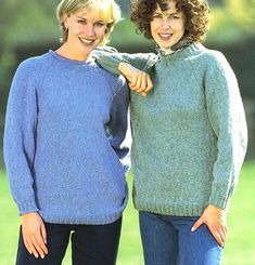 two women standing next to each other wearing sweaters