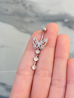 a person is holding a diamond butterfly brooch