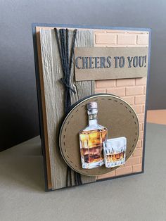 a card with a bottle of whiskey and two shot glasses on the front that says cheers to you