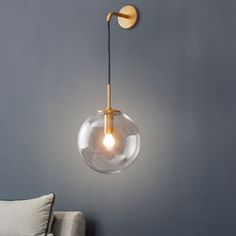 a light that is on the wall next to a couch in a room with grey walls