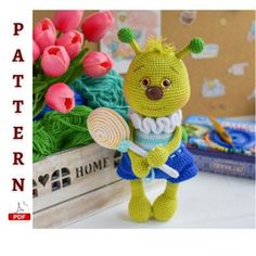 a crocheted stuffed animal holding a lollipop