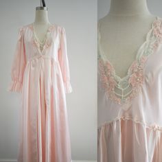 Description: 1990s pink satin nightgown and robe. 83% polyester/17% cotton. Both pieces are flannel lined. The gown has a deep V neckline and is sleeveless. It has a curved waist seam and a gathered skirt. The bodice and robe have lace trim, floral embroidery, and faux pearl beads. The robe has a V neckline and a front hook and eye closure. Long, full sleeves with ruffled cuffs and padded shoulders. Condition: In good condition, with no holes or stains. The flannel lining has some pilling. Laund Vintage Pink Sleepwear For Wedding Night, Pink Feminine Robe For Sleepover, Feminine Pink Robe For Daywear, Pink Satin Sleepwear For Spring, Spring Wedding Pink Nightgown, Feminine Pink Robe For Sleepover, Vintage Satin Sleepwear, Pink Feminine Robe, Pink Satin Nightgown For Loungewear