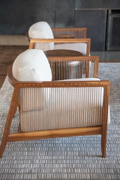 three wooden chairs with white pillows on them in a living room or dining room area