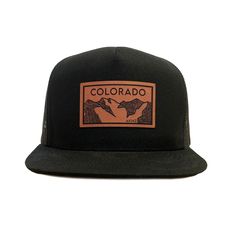 Colorado Elevation mountains faux leather patch in rawhide. Available in silver gray or black. Flat bill cotton twill front. Mesh back with adjustable snapback Outdoor Snapback Hat With Flat Brim, Black Hat With Leather Patch, Black Hats With Leather Patch, Black Hat With Leather Patch One Size, Rugged Outdoor Hat With Leather Patch, Black Hat With Leather Patch, One Size Fits Most, Rugged Adjustable Baseball Cap For Outdoor, Urban Trucker Hat With Logo Patch For Outdoor, Adjustable Baseball Cap With Leather Patch And Flat Brim