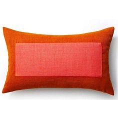 an orange and pink pillow on a white wall with a red stripe in the middle