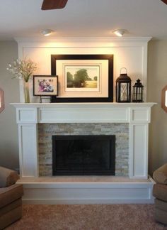 a living room with a fire place and pictures on the fireplace mantel above it