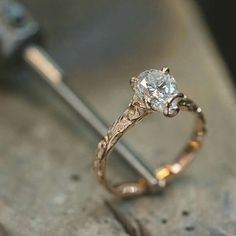 a close up of a ring with a diamond in the middle on a piece of wood