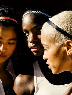 three women are looking at a cell phone