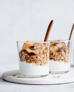 two glasses filled with granola and yogurt