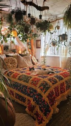 a bed covered in lots of plants next to a window