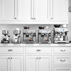 there are many different types of coffee machines on the counter top in this white kitchen