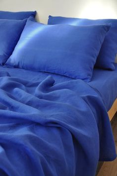 a bed with blue sheets and pillows on it