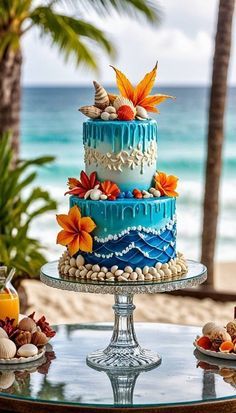 a three tiered cake sitting on top of a glass table next to the ocean