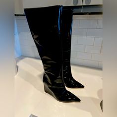 From The Asya Collection. Schutz’s Patent Leather Boots Feature A Pointed Toe And Side-Zip Closure. The Pair Is Elevated By A 109mm Wedge Heel. * 100% Patent Leather Upper * Pointed Toe * Side-Zip Closure * Synthetic Lining * 100% Leather Sole * Imported * True To Size * Wedge, 4.3” (109 Mm) * Shaft Height, 15.17” * Leg Opening, About 14.17” Trendy Leather Wedge Boots With Pointed Toe, Leather Wedge Boots For Party, Trendy Fitted Black Wedge Boots, Black Wedge Heel Boots For Party, Party Wedge Boots With Reinforced Heel, Casual Leather Wedge Boots For Party, Black Pointed Toe Wedge Boots, High Heel Wedge Boots For Office, Modern Black High Heel Wedge Boots