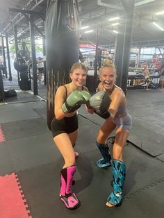 two women standing next to each other with boxing gloves on