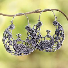 Among a garden of paisley motifs two peacocks add beauty to this pair of hoop earrings from Bali. Rupadana designs the earrings crafted of sterling silver. Ornate Handmade Hoop Earrings, Handmade Ornate Hoop Earrings, Oxidized Finish Chandbali Hoop Earrings, Bohemian Metal Earrings With Peacock Design, Silver Peacock Design Earrings, Bohemian Jewelry With Peacock Design, Bohemian Round Jewelry With Peacock Design, Sterling Silver Peacock Design Jewelry, Sterling Silver Round Peacock Design Jewelry