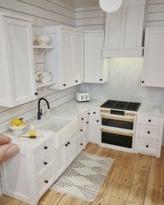 a kitchen with white cabinets and wood floors