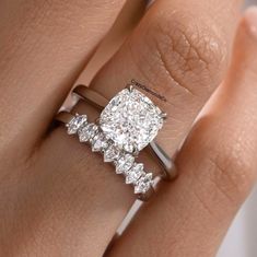 a woman's hand with an engagement ring on it and a diamond in the middle