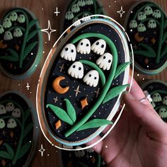 a hand holding a cupcake decorated with icing and spooky ghost decorations