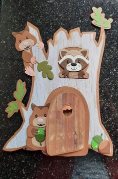 a wooden cutout of a tree house with animals and leaves on the outside wall