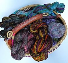 several skeins of yarn in a basket with a wooden stick sticking out of it