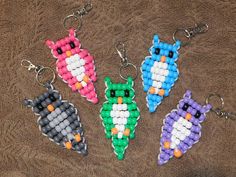 four different colored beads in the shape of an animal keychain on a brown surface