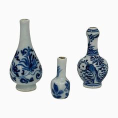 three blue and white vases sitting next to each other