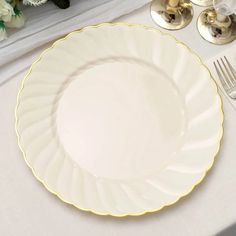 a white and gold table setting with silverware