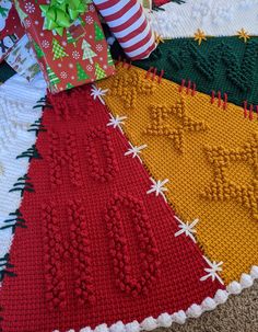 a knitted christmas tree skirt with presents on it