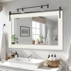 a white bathroom sink sitting under a large mirror