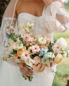 a bride holding a bouquet of flowers in her hands