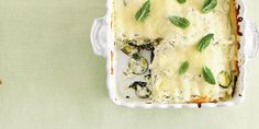 a casserole dish with spinach and cheese in it on a green tablecloth