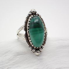 Key Words: Balance | Empathy | Responsibility Zodiac: ♑ Capricorn | ♏Scorpio Chakra: Heart Dimensions: Size 6 | 1.1" long | .5" wide Malachite is a striking green gemstone with unique banding patterns that captivate the eye. Its vibrant green color is often associated with growth, abundance, and transformation. Metaphysically, Malachite is considered a stone of deep healing and emotional balance. It is believed to absorb negative energies, release emotional blockages, and promote positive transf Vintage Green Jewelry With Large Stone, Adjustable Green Turquoise Ring In Spiritual Style, Adjustable Green Turquoise Ring, Spiritual Style, Adjustable Green Malachite Jewelry, Spiritual Green Ring With Large Stone, Adjustable Green Rings For May Birthstone, Adjustable Green Emerald Gemstone Ring, Oval Green Malachite Jewelry, Adjustable Green Rings With Large Stone