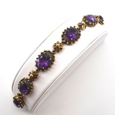 "Surprise your February birthday girl (or treat yourself) to this bold bracelet! This exquisite 14 karat solid yellow gold bracelet is prong-set with six oval-cut amethysts, each measuring 12 millimeters long by 10 millimeters wide by 6.5 millimeters deep, and each weighing an estimated 3.91 carats, for a total amethyst weight of 23.46 carats. The bracelet is 7 1/8 inches long by 15 millimeters (just under 5/8 inch) wide. Each stone is set in an oval textured and oxidized gold mount with each se Antique Purple Bracelets For Formal Occasions, Victorian Gemstone Bracelets As Gift, Gold Amethyst Bracelets For Formal Occasions, Antique Gold Bracelet For Gift, Victorian Hallmarked Bracelets, February Birthday, Wilmington Nc, Amethyst Bracelet, February Birthstone