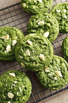 green cookies with white chocolate chips on a cooling rack