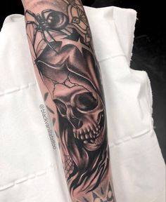 a man's arm with a black and grey skull tattoo on the left forearm