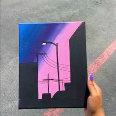 a person holding up a piece of art that looks like it is in the city