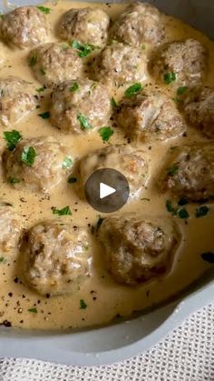 a pan filled with meatballs covered in gravy and garnished with parsley