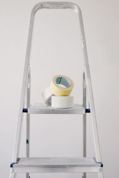 two rolls of tape on top of a step ladder