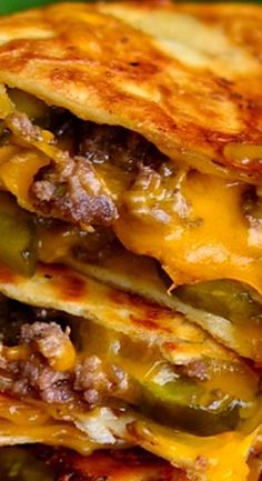 two quesadillas stacked on top of each other with cheese and green peppers