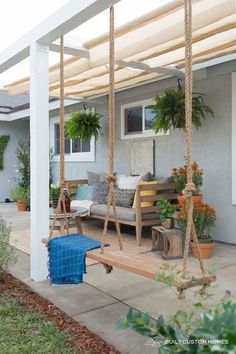 a porch with a swing and potted plants