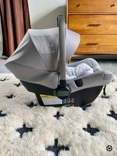 a baby car seat sitting on top of a rug