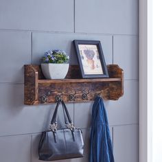 a wooden shelf holding two purses and a potted plant on top of it