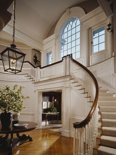 a staircase leading up to the second floor in a house with white walls and wood trimmings