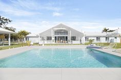 an empty swimming pool in front of a white house