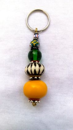 a keychain with three different beads on top of each other, one orange and the other green