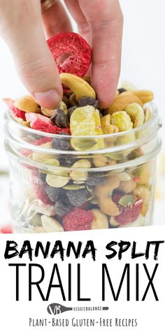 a hand picking up a banana split trail mix in a glass jar with text overlay that reads plant based banana split trail mix