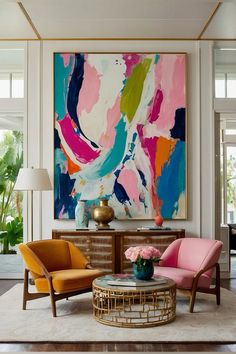 a living room filled with furniture and a large painting on the wall above it's coffee table