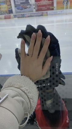 a woman's hand on top of an ice hockey glove